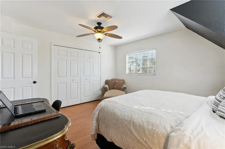 Bedroom with ceiling fan, a closet, and light hardwood / wood-style floors