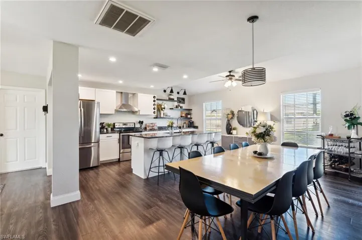 Dining area with ceiling fan, a healthy amount of sunlight, dark hardwood / wood-style flooring, and sink
