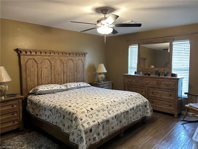 Bedroom with ceiling fan and dark wood-type flooring