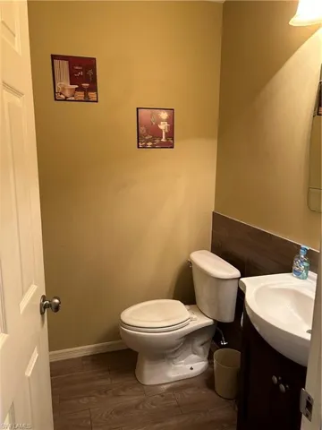 Bathroom featuring wood-type flooring, vanity, and toilet