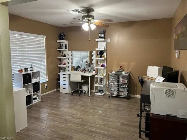 Office space featuring dark hardwood / wood-style floors and ceiling fan
