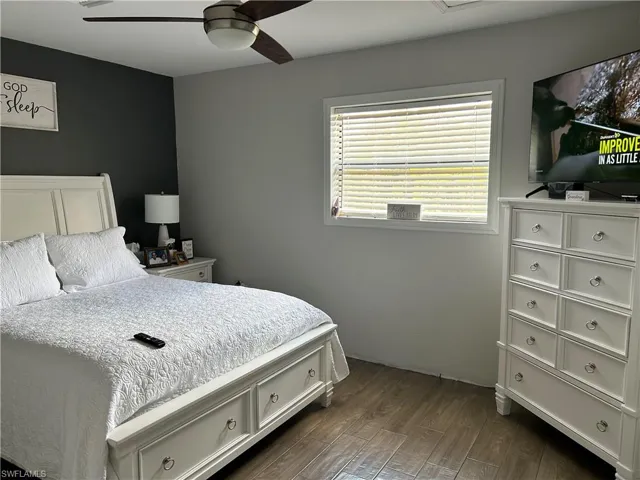 Bedroom with dark hardwood / wood-style floors and ceiling fan