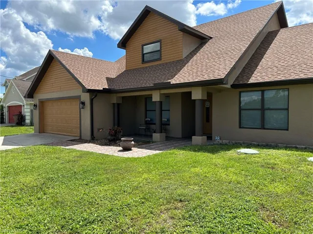 View of front of house featuring a porch, a garage, and a front yard