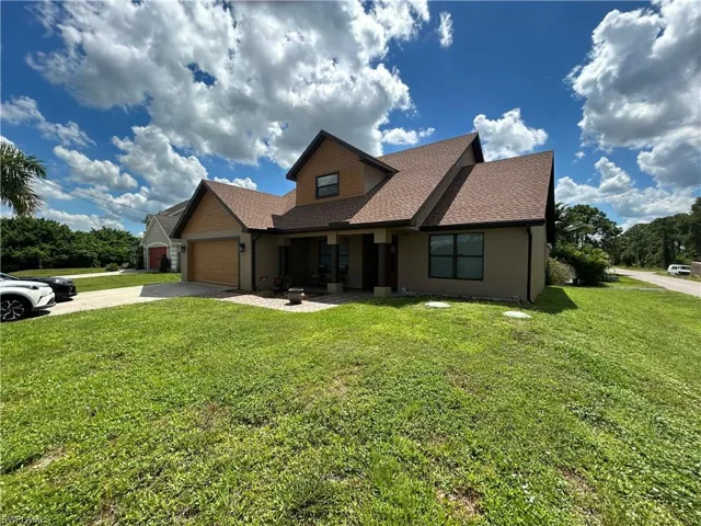 View of front of property with a garage and a front lawn