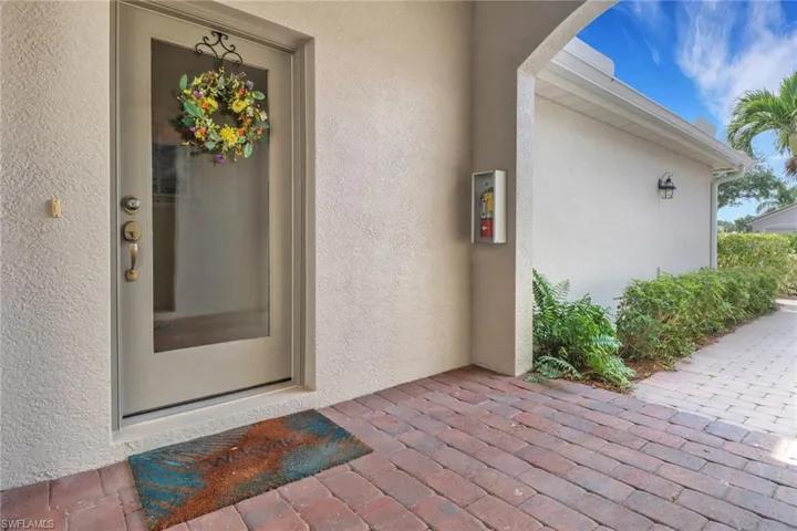 Doorway to property with stucco siding and a patio area