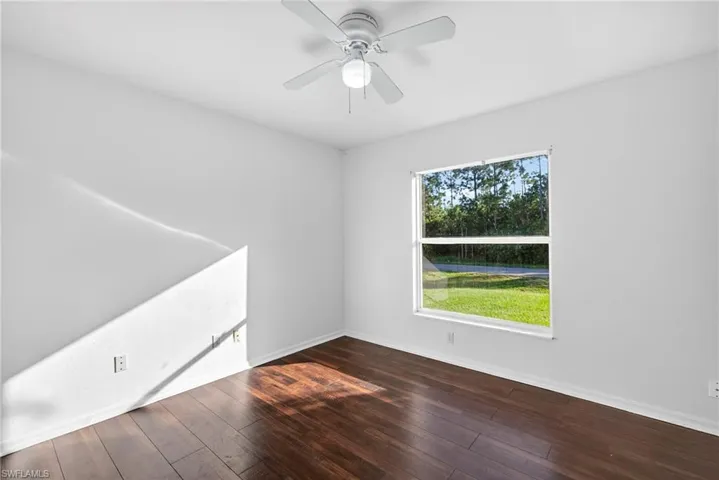 Spare room featuring dark wood-style floors and ceiling fan