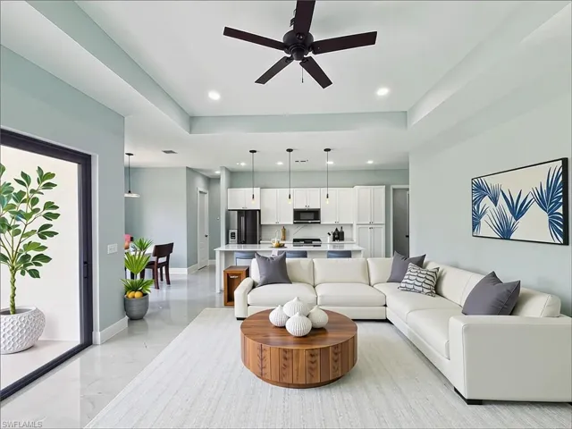 Living room with ceiling fan, recessed lighting, and light marble finish flooring