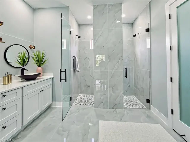 Bathroom featuring marble finish flooring, vanity, a marble finish shower, and recessed lighting