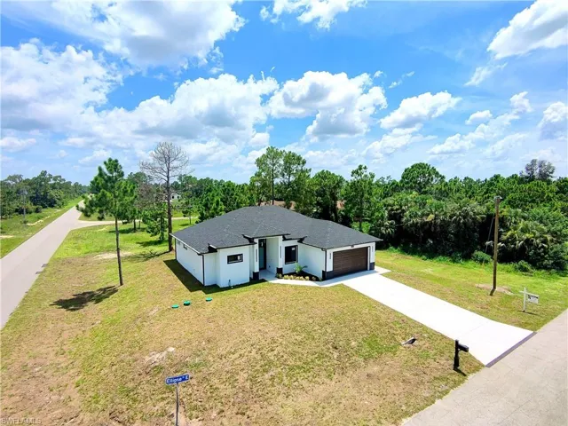 View of front of property with driveway, a garage, a front lawn, and roof with shingles