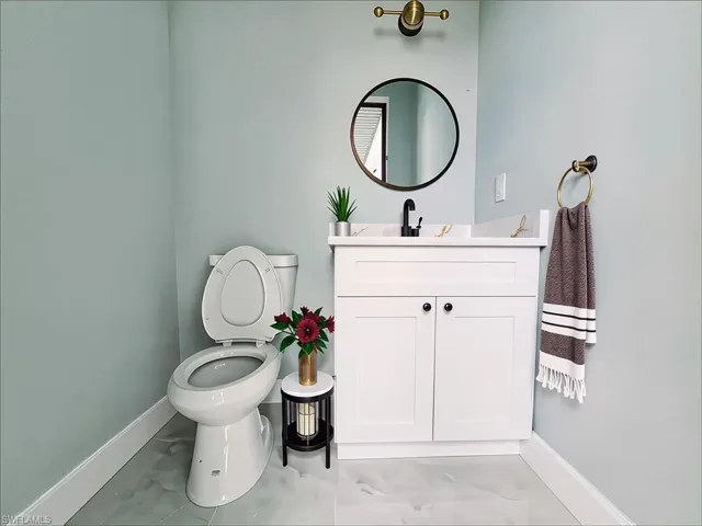 Bathroom with marble finish flooring and vanity