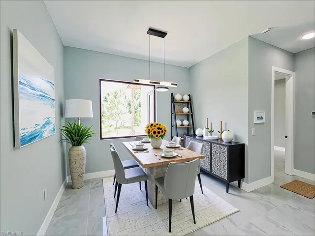 Dining area with light marble finish flooring and a chandelier