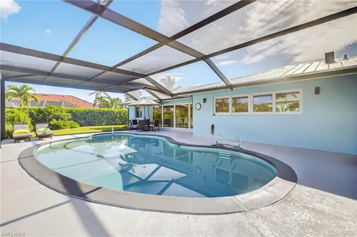 Swimming pool with a patio area and glass enclosure