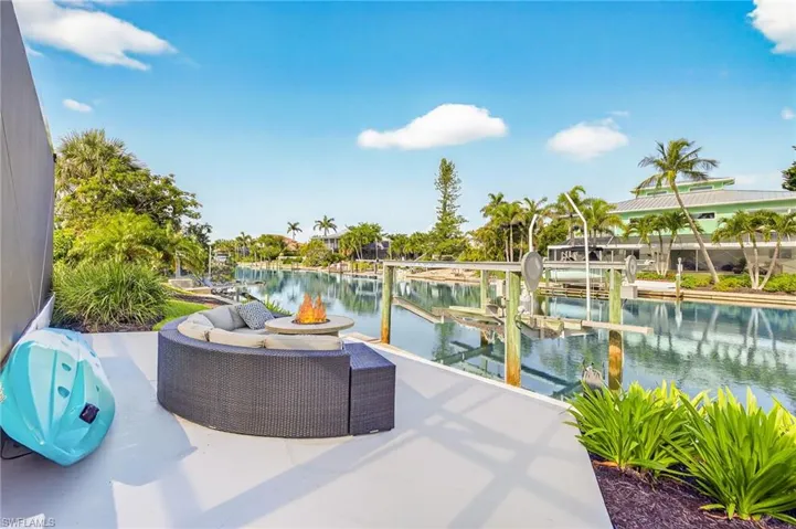 View of patio with a water view, a boat dock, and boat lift