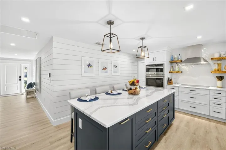 Kitchen featuring open shelves, white cabinets, wall chimney range hood, recessed lighting, and light wood-style flooring