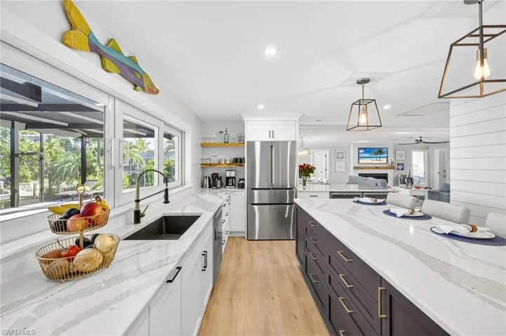 Kitchen with healthy amount of natural light, white cabinetry, light wood finished floors, appliances with stainless steel finishes, and recessed lighting