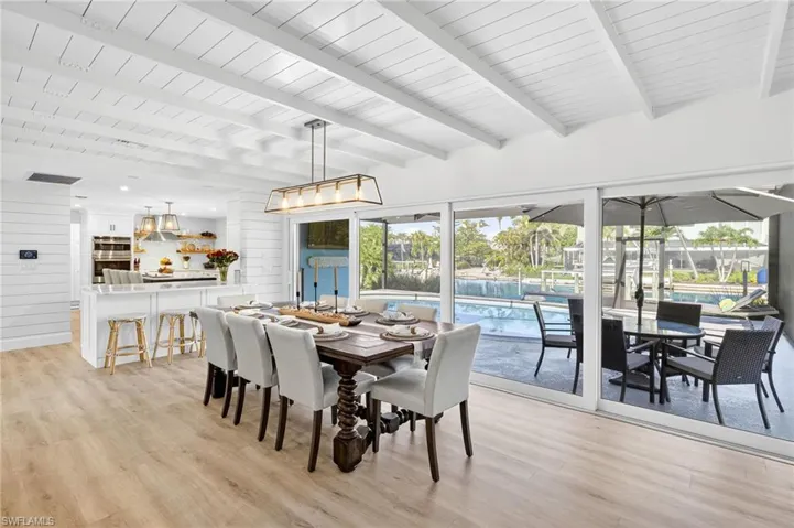 Dining room with light wood-style floors and a wood ceiling with exposed beams