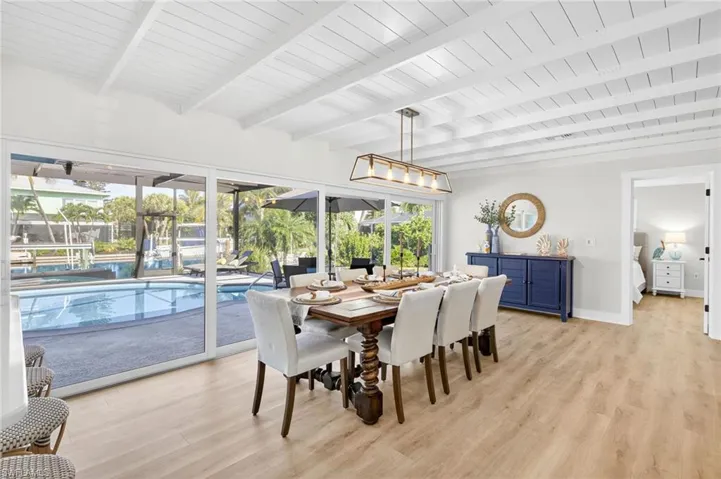 Dining area with light wood finished floors and a wooden ceiling with exposed beams