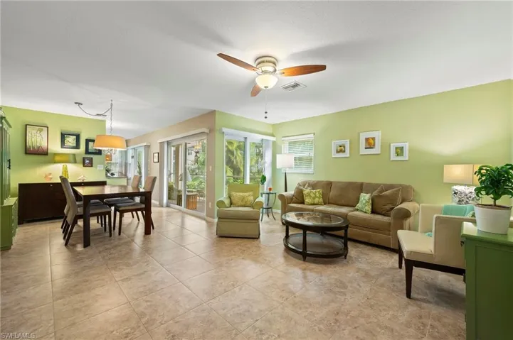 Living room and dining area. With light tile patterned flooring and ceiling fan