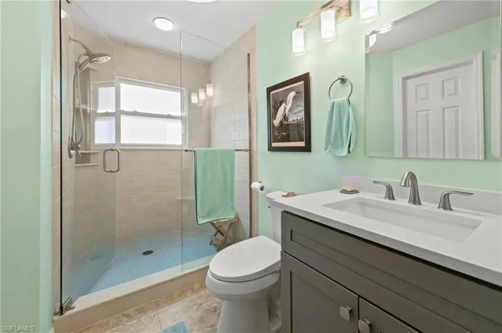 Full bath featuring vanity, toilet, and a shower stall