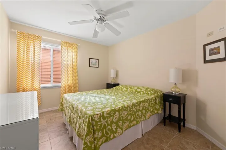 Tiled 3rd bedroom with ceiling fan and baseboards