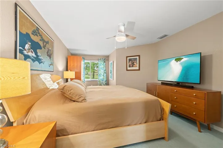Carpeted bedroom featuring baseboards and ceiling fan