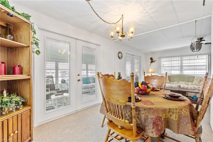 Dining space with french doors, carpet, and a chandelier