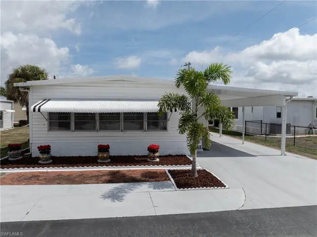 View of front of house featuring concrete driveway and an attached carport