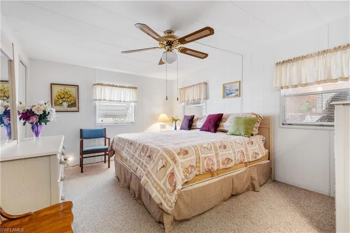 Bedroom with light colored carpet and ceiling fan