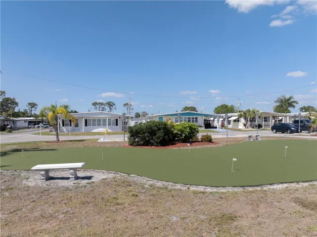 View of property's community featuring a putting area and a residential view