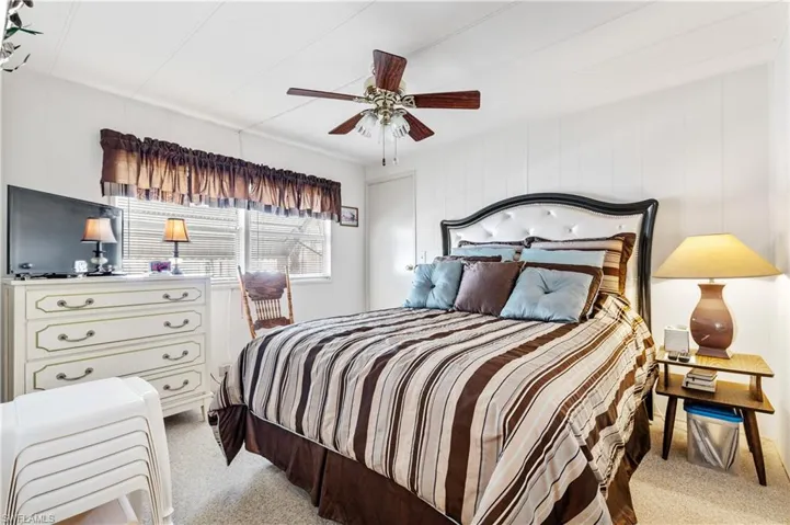 Bedroom with a ceiling fan and light carpet