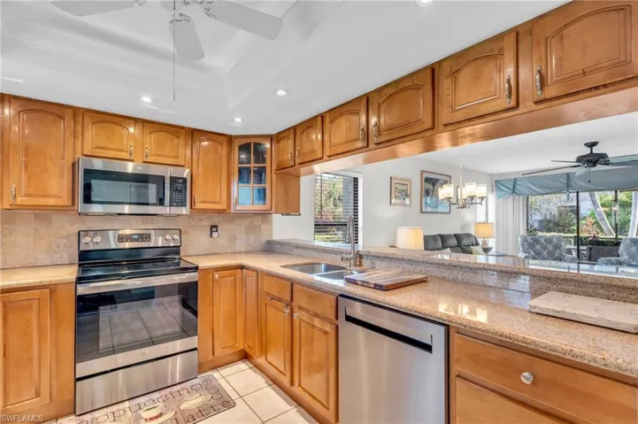 Kitchen with new stainless steel appliances  granite counters, ceiling fan, breakfast bar