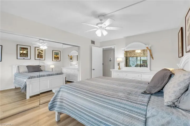 Guest Bedroom featuring access to exterior lanai, new flooring, ceiling fan, spacious closet with mirrors