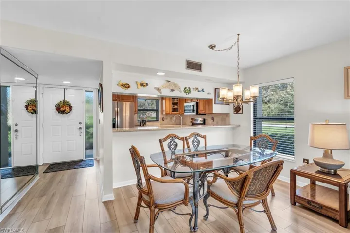 Dining area with chandelier, breakfast bar, kitchen, foyer