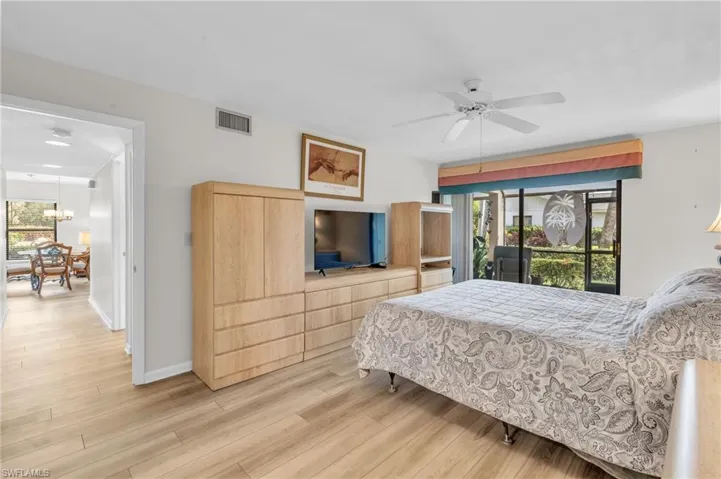 Bedroom suite with access to exterior lanai, ceiling fan, furniture