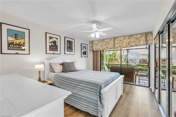 Guest Bedroom featuring access to exterior lanai, lnew flooring, ceiling fan, spacious closet with mirrors