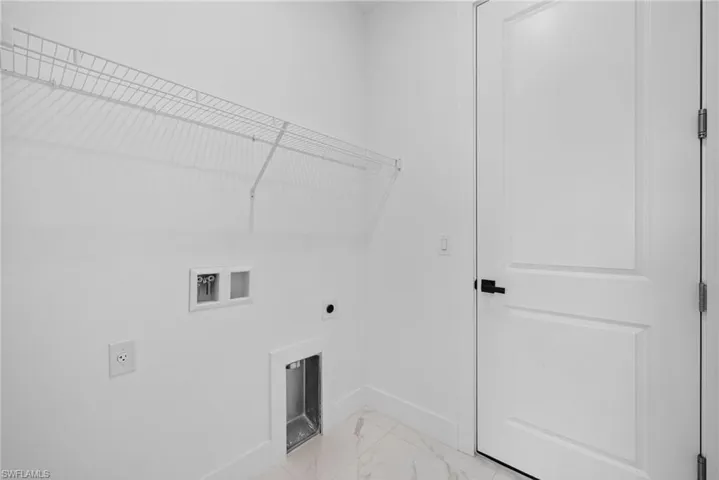 Laundry room with washer hookup, electric dryer hookup, and light marble finish flooring