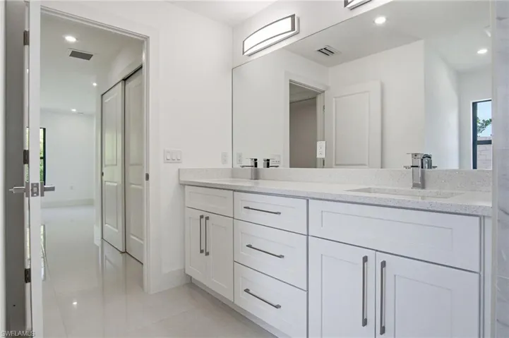 Double vanity with integrated sinks, speckled countertops, and chrome fixtures