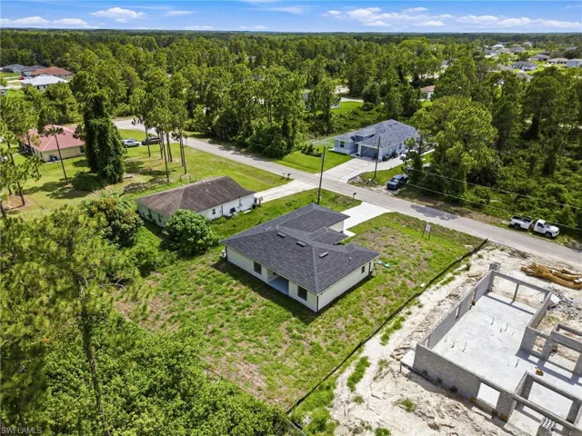 Newly constructed residence featuring a white exterior, dark shingle roof, and an attached concrete driveway