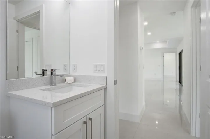 Bathroom vanity with a white rectangular undermount sink, a chrome faucet, and a light-colored speckled countertop