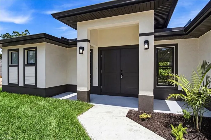 Contemporary exterior showcasing a neutral stucco finish with contrasting dark trim