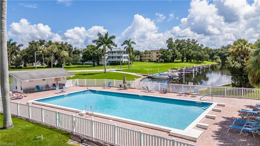 View of pool with a patio area, a lawn, and a water view