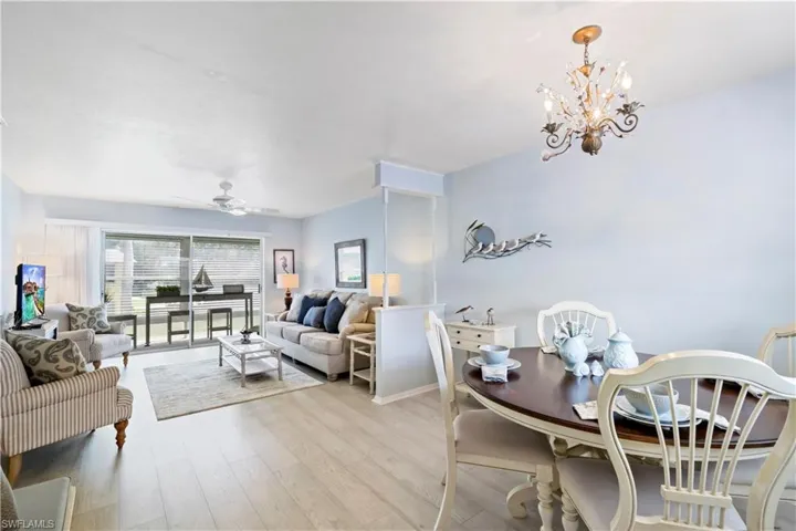 Dining space with ceiling fan with notable chandelier and light hardwood / wood-style floors