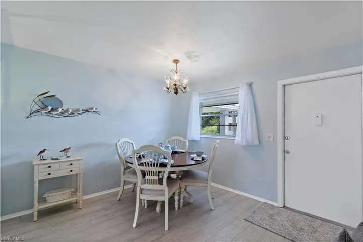 Dining room with light hardwood / wood-style flooring and a notable chandelier