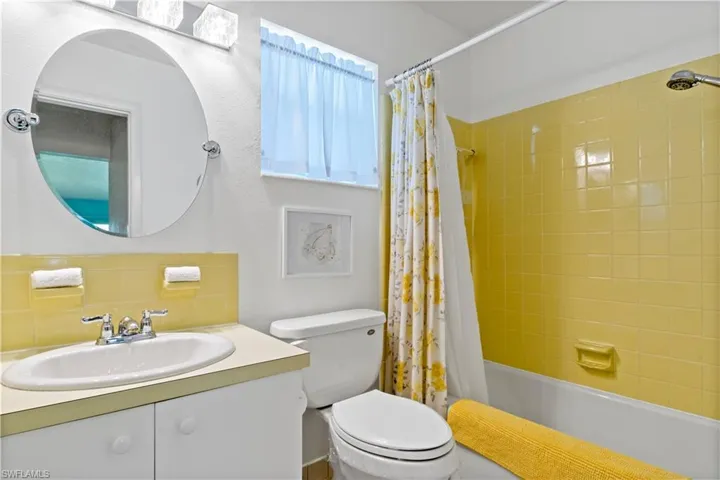 Full bathroom featuring vanity, toilet, shower / tub combo, and tasteful backsplash