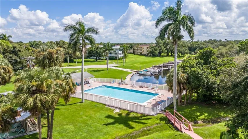 View of swimming pool with a water view and a lawn
