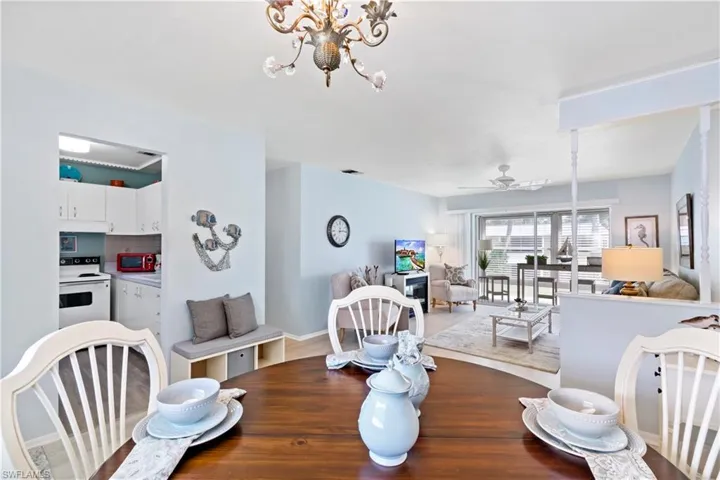 Dining room with ceiling fan with notable chandelier and hardwood / wood-style floors