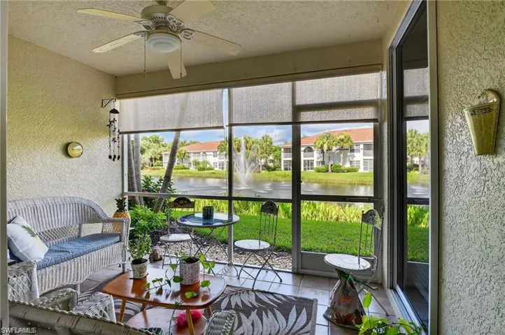 Sunroom featuring ceiling fan and a water view