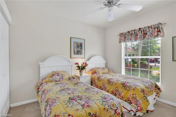 Bedroom featuring light carpet, ceiling fan, and a closet