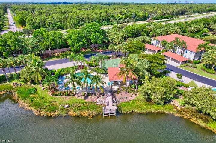 Drone / aerial view of a nearby body of water and a pool area