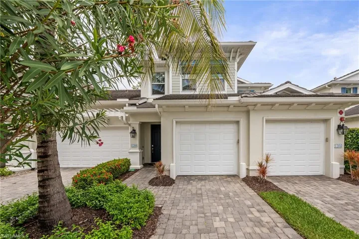 Multi-level exterior with white siding and tile roofing